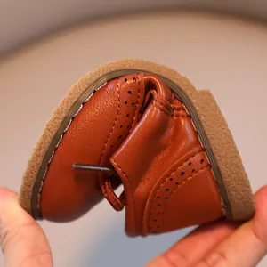 Detailed view of flexible soft leather brown shoes for children showing softness