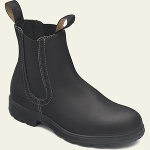 Primer plano de botas Chelsea de cuero negro con elegantes detalles brogue en las costuras