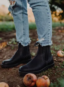 Vistas de estilo de vida de botas Chelsea negras para mujer combinadas con jeans rasgados