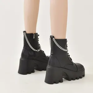 Vue détaillée de bottes noires à plateforme avec une chaîne argentée au dos