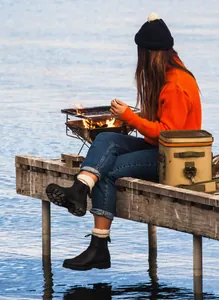 Primer plano de botas Chelsea negras de mujer en un muelle de madera