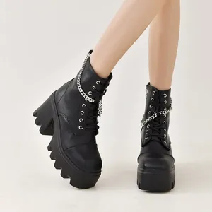 Vue détaillée de bottines noires à plateforme avec chaîne argentée et lacets.