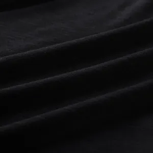 Detailed macro view showing the soft black knit fabric texture of a slim-fit jumpsuit.