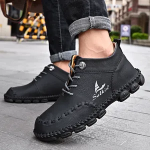 Close-up of black hand-stitched mid-top work boots for men in an outdoor setting