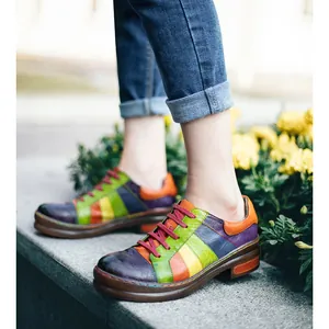 Detailed macro view of handmade colorful patchwork genuine leather shoes worn with blue jeans.