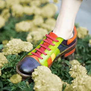 Macro view of vibrant colorful patchwork leather shoes shown in a floral garden setting
