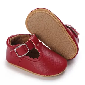 Macro detail view of red baby T-strap shoes showing the anti-slip soft sole texture