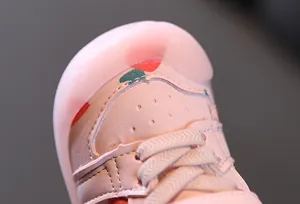 Détail en gros plan du bout d'une chaussure rose pour bébé avec un motif de cœur mignon