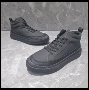 Vue de côté des bottes hautes en cuir noir pour hommes sur fond de marbre gris