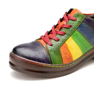Close-up detail of colorful patchwork leather shoes with embossed floral patterns.