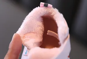 Gros plan sur la doublure en peluche rose douce des chaussures d'hiver bébé