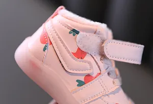 Détail d'une chaussure d'hiver rose pour bébé avec motif fraise et doublure en fourrure