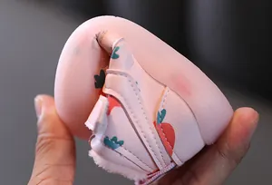 Gros plan d'une chaussure rose pour bébé avec motif carotte et semelle souple flexible