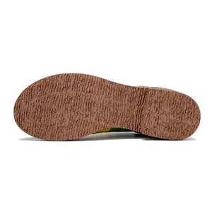 Macro detail showing the durable anti-slip textured rubber sole of colorful leather shoes.