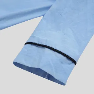 Close-up detail of light blue men's sleepshirt sleeve with elegant black piping.