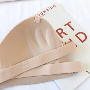 Close-up detail showing the unique palm-shaped push-up padding of a nude strapless bra.