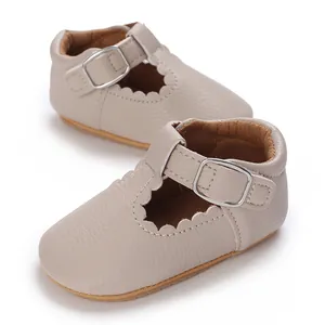 Detail view of beige soft-sole baby leather shoes with T-strap and metal buckle