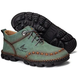 Detailed close-up showing hand-stitched seams and teal nubuck texture on men's mid-top boots.