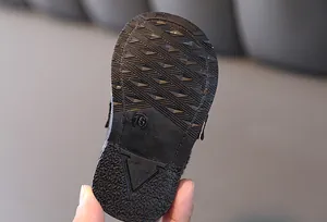 Dettaglio ravvicinato della suola in gomma nera antiscivolo per scarpe primi passi bimbo