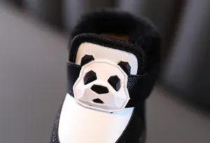 Macro detail of warm winter baby snow boots featuring a cute 3D geometric panda decoration