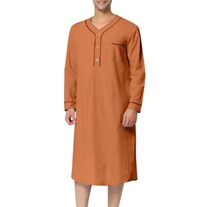 Detail view of men's long-sleeved orange ethnic loungewear with contrast black piping