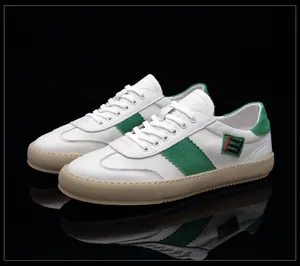 Vue détaillée de baskets pour homme en cuir blanc avec accents en daim vert élégants