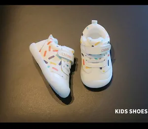 Close-up of white toddler walking shoes featuring soft fleece lining and colorful patterns.