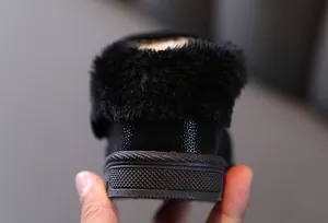 Detail view of black toddler winter boots showing plush lining and non-slip sole.