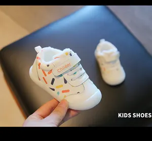 Detail of warm white toddler walking shoes with soft lining and colorful patterns.
