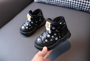 Dettaglio di stivali da neve per bambini con fodera in pile, pois e suole morbide.