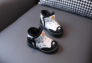Dettaglio di stivali da neve a LED per bambini con pois neri e calda fodera in pile.