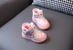 Primo piano di stivali da neve LED rosa a pois con calda fodera in pile per bambini.
