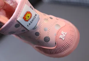 Dettaglio della fodera in peluche caldo e del logo del leone sugli stivali rosa per neonati