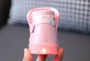 Dettaglio ravvicinato della suola LED luminosa di questi stivali da neve rosa per bambini