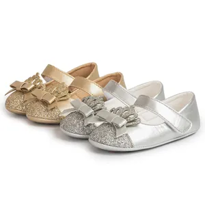 Detail of sparkling gold and silver toddler princess shoes with crown and bow.
