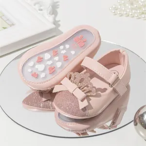 Detailed macro view of pink glittery baby princess shoes with crown and bow decoration