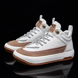 Detail view of high-top white leather sneakers with brown suede accents and rubber sole.
