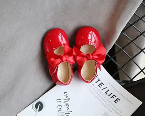 Detailansicht glänzender roter Lacklederschuhe für Mädchen mit großer Schleife