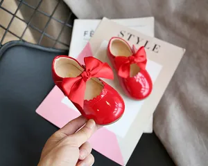 Nahaufnahme roter Lacklederschuhe für Kleinkinder mit eleganter Schleife