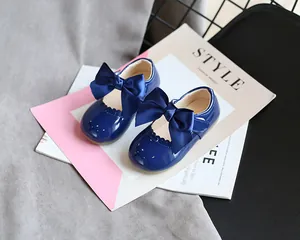 Nahaufnahme von dunkelblauen Lacklederschuhen für Mädchen mit eleganten Schleifenverzierung