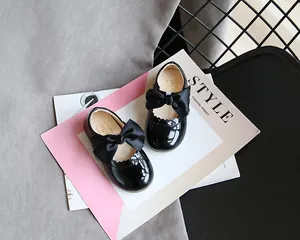 Detailansicht glänzender schwarzer Lacklederschuhe für Mädchen mit eleganten Schleifen