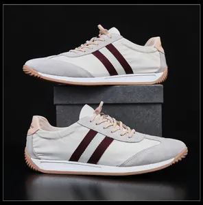 Vue détaillée de baskets blanches pour hommes avec bandes latérales marron classiques.