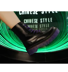Detail view of black platform Martin boots with purple laces and translucent sole.
