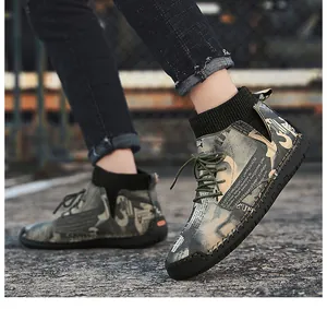 Detailed side view of stylish men's camouflage high-top casual boots on urban street pavement