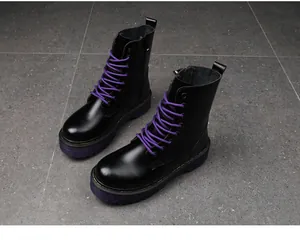 Close-up of black platform Martin boots with vibrant purple laces and thick sole.