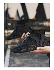 Detailed side view of stylish grey mid-top men's casual shoes held by hand