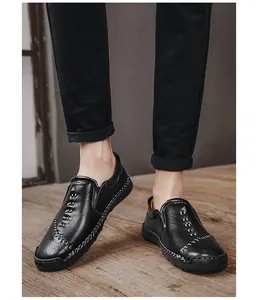 Close-up detail van casual zwarte herenloafers met ambachtelijke witte handstikseldetails.