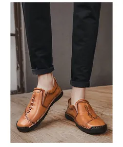 Detailweergave van bruine handgestikte leren herenloafers gedragen door een model
