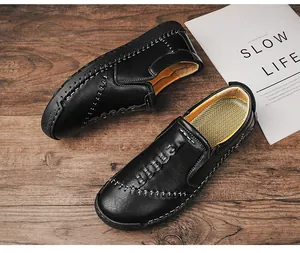 Detail van zwarte handgestikte heren loafers op een houten oppervlak