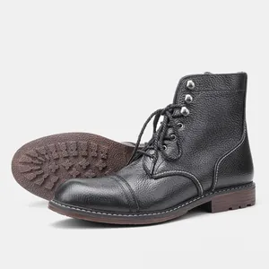 Vista detallada de la textura de cuero negro y la suela robusta de botas de trabajo
